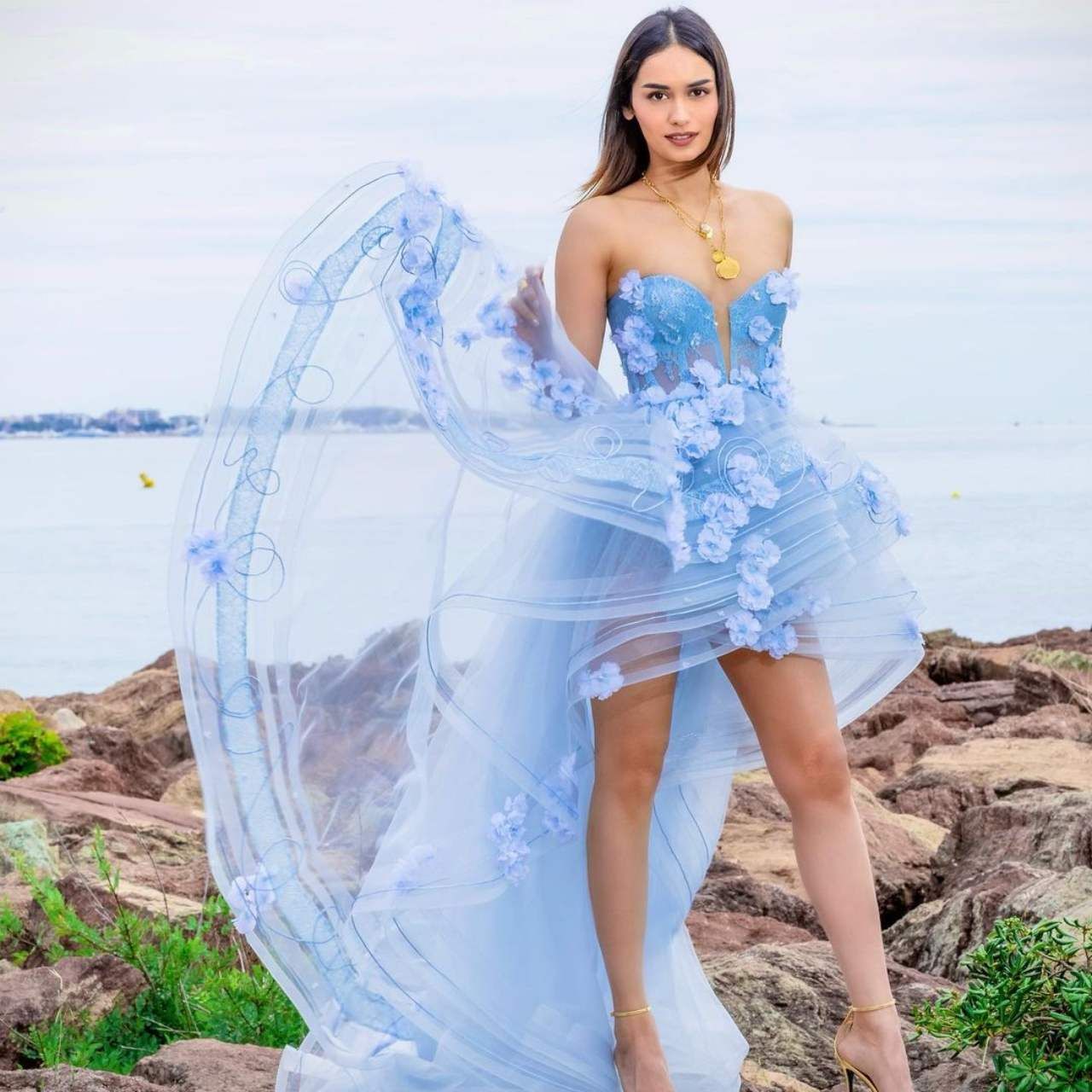 Manushi Chhillar - Actress Manushi Chhillar has worn a pastel transparent gown of blue color in this picture.  For accessories, the actress wore golden pendant and golden high heels.